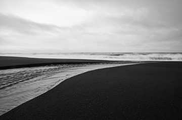 Photograph of surf of black sand beach
